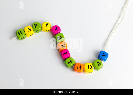 Toy blocks spelling out 'HAPPY BIRTHDAY' sur un fond blanc. Banque D'Images