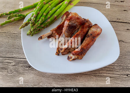 Le dîner de la viande de bœuf grillé servi avec des asperges sur les côtes de la plaque en bois Banque D'Images