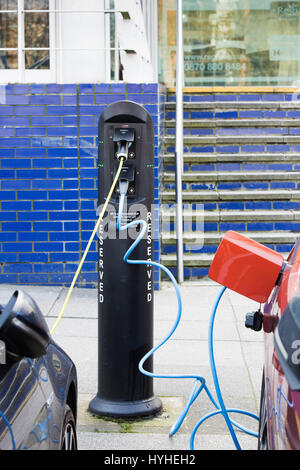 La recharge de batteries de voiture électrique à une borne de charge. Milton Keynes, Buckinghamshire, Angleterre Banque D'Images