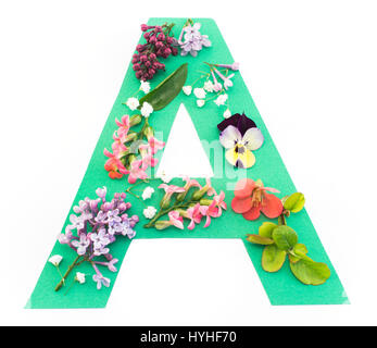 Une lettre faite de fleurs de printemps et papier, sur fond blanc. Banque D'Images