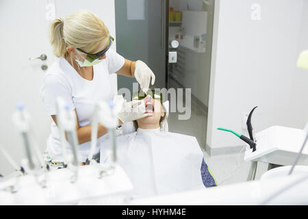 Dentiste à l'aide d'une diode laser dentaire moderne de soins parodontaux. Les deux portant des lunettes, prévenir les dommages de la vue. La parodontite, dentaire hyg Banque D'Images