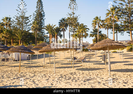 Des parasols de paille sur la plage en bord de vide en Grèce Banque D'Images