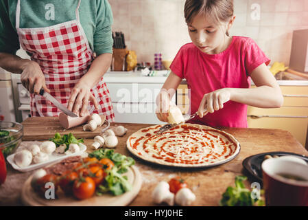 Mère et fille la préparation de pizza dans la cuisine Banque D'Images