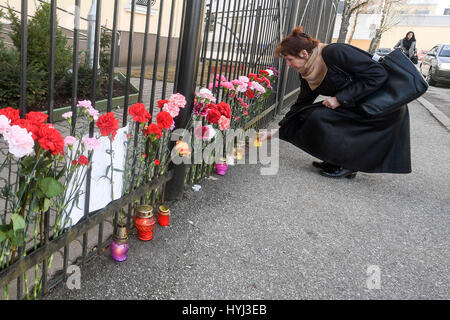 Narva, Estonie. Le 4 avril 2017. Une femme met une bougie pour pleurer les victimes de l'explosion de Saint-pétersbourg près de la clôture de la Fédération de Russie Consulat Général à Narva, Estonie, en avril. 4, 2017. Source : Xinhua/Alamy Live News Banque D'Images