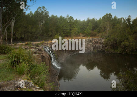 En cascade cascade plus haute falaise rocheuse en eaux calmes profonds à Tooloom chutes chez les forêts du nord de l'Australie NSW Banque D'Images