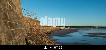 Le mur de la mer par la baie de Saint-ouen, Jersey à marée basse avec des bancs de sable dans l'après-midi, soleil de l'été Banque D'Images