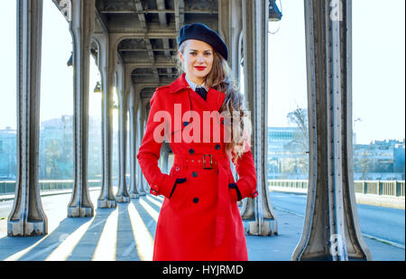 Brillante dans Paris. Portrait de jeune femme en trench-coat rouge sur le Pont de Bir-Hakeim pont de Paris Banque D'Images