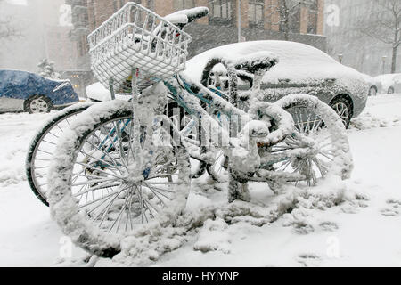 Deux bicyles enchaînés à un rack à l'extérieur sont couvertes de neige pendant une chute de neige à Manhattan. Banque D'Images