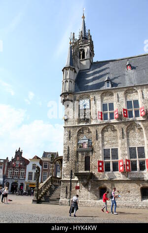 Les gens se promener sur la pittoresque place du marché de Gouda avec gothique du Xvème siècle emblématique Hôtel de ville (Stadhuis), Gouda, Pays-Bas Banque D'Images