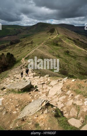 Les marcheurs en remontant la voie rocheuse escarpée à Tor Retour sur la crête à pied de Mam Tor, Peak District, l'Angleterre. Banque D'Images