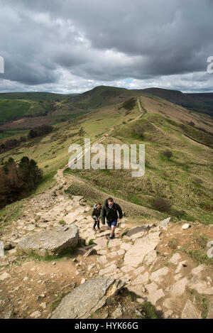 Les marcheurs en remontant la voie rocheuse escarpée à Tor Retour sur la crête à pied de Mam Tor, Peak District, l'Angleterre. Banque D'Images