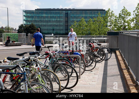 Prêt de vélos garés dans le grenier Square par Regent's Canal, King's Cross, en regardant vers l'immeuble de verre, plaqué Kings Place, Londres Banque D'Images