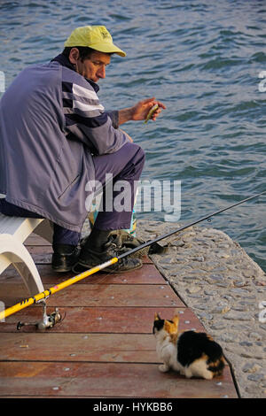 Pêcheur avec traiter pour chat sur un quai du lac Ohrid, Macédoine. Banque D'Images