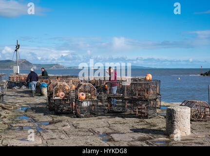 Les pêcheurs réparer leurs casiers à homard sur le mur du port à Lyme Regis Banque D'Images