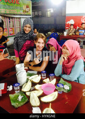 Granny moto Stephanie Jeavons essayant durian fruit avec les filles locales à Sumatra, en Indonésie. Rencontrez la femme biker qui est devenu le premier britannique à monter l'Antarctique et pourrait être le pays le plus bien-parcouru GRAND-MÈRE. Un an depuis le début de son voyage, cet intrépide dame a parcouru 30 000 km dans le cadre de sa quête pour devenir le premier britannique à voyager tous les sept continents de la planète, le tout sur un budget de seulement £ 15 par jour. Après trois grèves bravant par des icebergs, ancien propriétaire de l'école moto Stephanie Jeavons (40), de Colwyn Bay, Pays de Galles est devenu le premier britannique à jamais atteindre Antarcti Banque D'Images