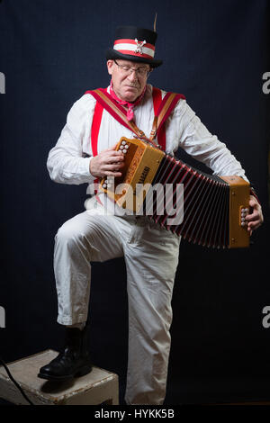 SURREY, UK : UNE Morris homme en costume traditionnel. Une célébration de la plus pure tradition de la danse Morris men a été révélé par un résident de Surrey sur la journée la plus importante de la tradition peut jour. Les images montrent les différents âges et les costumes de cette troupe de danseurs Morris dans portraits intimes. L'uniforme rouge et blanc avec des cloches et des rubans attachés ainsi que des hauts-de-forme, des bâtons, des accordéons et des violons accompagnent le groupe de danse. Filip photographe Jacek Gierlinski (39) a invité sa troupe locale de Morris men à un studio installé dans une église située sur Ewell, Surrey. Banque D'Images