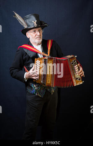 SURREY, UK : UNE Morris homme en costume traditionnel. Une célébration de la plus pure tradition de la danse Morris men a été révélé par un résident de Surrey sur la journée la plus importante de la tradition peut jour. Les images montrent les différents âges et les costumes de cette troupe de danseurs Morris dans portraits intimes. L'uniforme rouge et blanc avec des cloches et des rubans attachés ainsi que des hauts-de-forme, des bâtons, des accordéons et des violons accompagnent le groupe de danse. Filip photographe Jacek Gierlinski (39) a invité sa troupe locale de Morris men à un studio installé dans une église située sur Ewell, Surrey. Banque D'Images