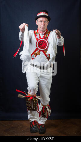 SURREY, UK : UNE Morris homme en costume traditionnel. Une célébration de la plus pure tradition de la danse Morris men a été révélé par un résident de Surrey sur la journée la plus importante de la tradition peut jour. Les images montrent les différents âges et les costumes de cette troupe de danseurs Morris dans portraits intimes. L'uniforme rouge et blanc avec des cloches et des rubans attachés ainsi que des hauts-de-forme, des bâtons, des accordéons et des violons accompagnent le groupe de danse. Filip photographe Jacek Gierlinski (39) a invité sa troupe locale de Morris men à un studio installé dans une église située sur Ewell, Surrey. Banque D'Images