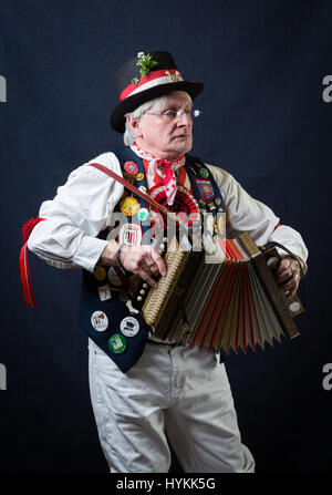 SURREY, UK : UNE Morris homme en costume traditionnel. Une célébration de la plus pure tradition de la danse Morris men a été révélé par un résident de Surrey sur la journée la plus importante de la tradition peut jour. Les images montrent les différents âges et les costumes de cette troupe de danseurs Morris dans portraits intimes. L'uniforme rouge et blanc avec des cloches et des rubans attachés ainsi que des hauts-de-forme, des bâtons, des accordéons et des violons accompagnent le groupe de danse. Filip photographe Jacek Gierlinski (39) a invité sa troupe locale de Morris men à un studio installé dans une église située sur Ewell, Surrey. Banque D'Images