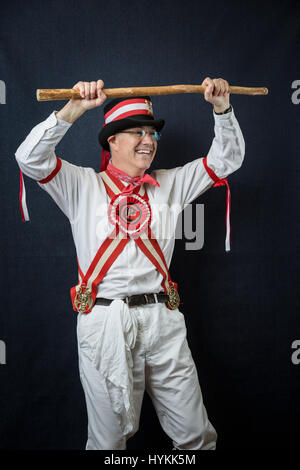 SURREY, UK : UNE Morris homme en costume traditionnel. Une célébration de la plus pure tradition de la danse Morris men a été révélé par un résident de Surrey sur la journée la plus importante de la tradition peut jour. Les images montrent les différents âges et les costumes de cette troupe de danseurs Morris dans portraits intimes. L'uniforme rouge et blanc avec des cloches et des rubans attachés ainsi que des hauts-de-forme, des bâtons, des accordéons et des violons accompagnent le groupe de danse. Filip photographe Jacek Gierlinski (39) a invité sa troupe locale de Morris men à un studio installé dans une église située sur Ewell, Surrey. Banque D'Images