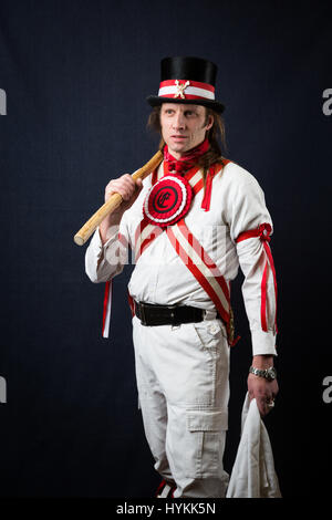 SURREY, UK : UNE Morris homme en costume traditionnel. Une célébration de la plus pure tradition de la danse Morris men a été révélé par un résident de Surrey sur la journée la plus importante de la tradition peut jour. Les images montrent les différents âges et les costumes de cette troupe de danseurs Morris dans portraits intimes. L'uniforme rouge et blanc avec des cloches et des rubans attachés ainsi que des hauts-de-forme, des bâtons, des accordéons et des violons accompagnent le groupe de danse. Filip photographe Jacek Gierlinski (39) a invité sa troupe locale de Morris men à un studio installé dans une église située sur Ewell, Surrey. Banque D'Images