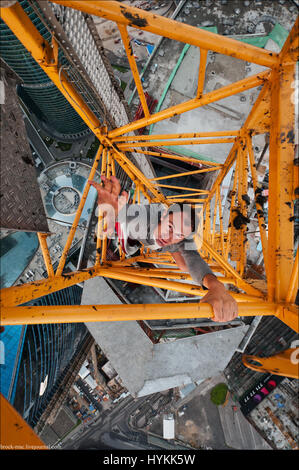 Moscou. VERTIGO induisant des images de la page d'un 155 mètres de haut crane ont été capturés par un photographe en vue de surmonter sa peur des hauteurs. L'incroyable d'images aériennes montrent le photographe et ses amis jettent de la prudence qu'ils précairement perché au-dessus des villes avec aucun équipement de sécurité. La capture d'autres coups de botte d'aventure au milieu de monte jusqu'grues et belles femmes posant sur le bord du toit. L'extrême photos ont été prises par Moscou et photographe George acrophobic Lanchevsky (24) dans les villes autour du monde, notamment Moscou, Galitch et Hong Kong. Banque D'Images