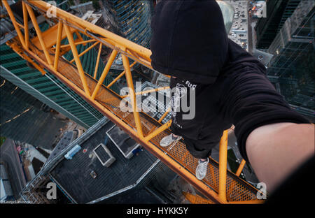 Moscou. VERTIGO induisant des images de la page d'un 155 mètres de haut crane ont été capturés par un photographe en vue de surmonter sa peur des hauteurs. L'incroyable d'images aériennes montrent le photographe et ses amis jettent de la prudence qu'ils précairement perché au-dessus des villes avec aucun équipement de sécurité. La capture d'autres coups de botte d'aventure au milieu de monte jusqu'grues et belles femmes posant sur le bord du toit. L'extrême photos ont été prises par Moscou et photographe George acrophobic Lanchevsky (24) dans les villes autour du monde, notamment Moscou, Galitch et Hong Kong. Banque D'Images