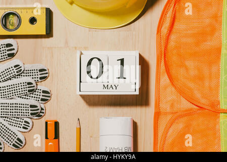 Le 1er mai. Droit de mai 1 blocs blanc calendrier en bois avec des outils de construction sur la table. La Journée internationale du Travail. Concept de la fête du travail. Banque D'Images