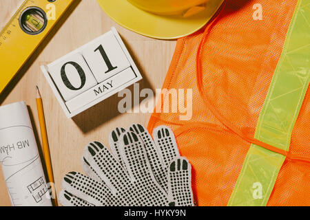 Le 1er mai. Droit de mai 1 blocs blanc calendrier en bois avec des outils de construction sur la table. La Journée internationale du Travail. Concept de la fête du travail. Banque D'Images