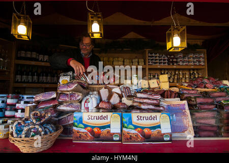 Un exposant dans son stand de produits typiques au marchés de Noël traditionnels de Bolzano, en Italie. Banque D'Images