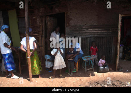 Les gens assis dans la rue, dans les bidonvilles de Kibera, Nairobi, Kenya, Afrique de l'Est Banque D'Images