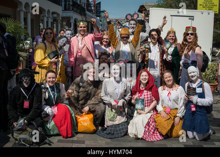 Un groupe d'acteurs et d'artistes de théâtre heureux dressed in costumes posent pour une photo de groupe dans la rue pendant la Brighton Fringe arts festival.​ Banque D'Images