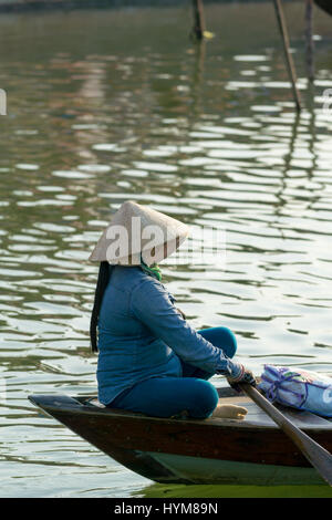 Hoi An Vietnam - 20 février 2017 - L'boatwoman nationale vietnamienne sur l'ancien bateau le long de la rivière Thu Bong. Banque D'Images