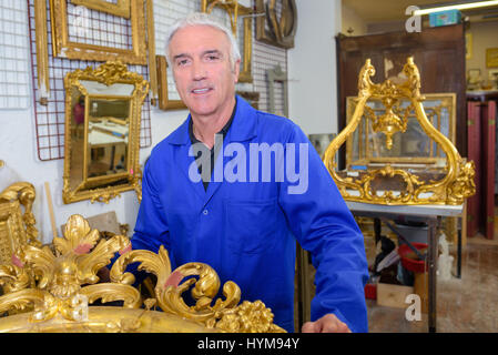 Portrait d'homme en atelier avec des cadres Banque D'Images