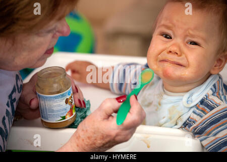 Grand-mère très malheureuse à nourrir son petit-fils. Grand-mère l'âge de 74 ans et 7 mois, bébé polonais. Zawady Europe centrale Pologne Banque D'Images
