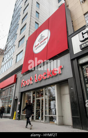 Une femme marche d'un magasin Foot Locker à Manhattan. Banque D'Images