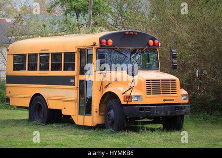 Autobus scolaire jaune abandonné dans lot vide Banque D'Images