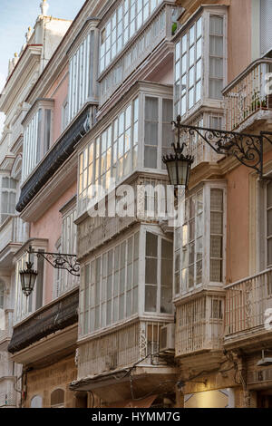 Détail d'un balcon et de grandes fenêtres sur le temps du xixe siècle, rue étroite à l'architecture traditionnelle à Cadix, Andalousie, Espagne Banque D'Images