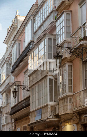 Détail d'un balcon et de grandes fenêtres sur le temps du xixe siècle, rue étroite à l'architecture traditionnelle à Cadix, Andalousie, Espagne Banque D'Images