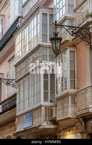 Détail d'un balcon et de grandes fenêtres sur le temps du xixe siècle, rue étroite à l'architecture traditionnelle à Cadix, Andalousie, Espagne Banque D'Images