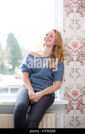 Portrait of a young woman laughing at home Banque D'Images