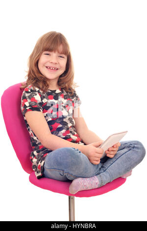 Petite fille assise sur une chaise et jouer avec tablet pc Banque D'Images