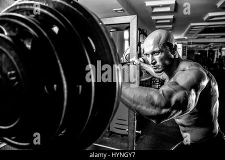 Bodybuilder chauve préparait pour l'exercice d'haltères avec in gym Banque D'Images