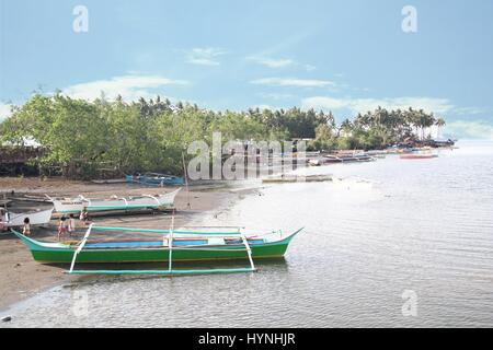 Village de pêcheurs, la ville de Davao, Philippines enfants jouent entre les bateaux à marée basse au village de pêche dans la ville de Davao, Philippines. Banque D'Images