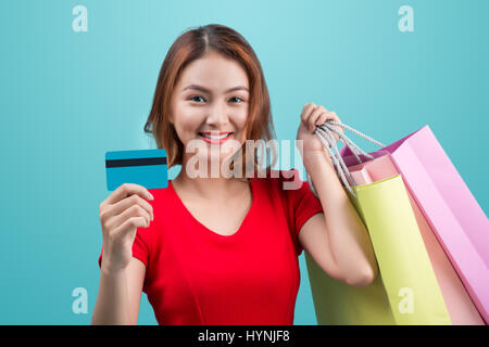 Santa asian woman holding shopping bags, une carte de crédit contre la vignette bleue Banque D'Images