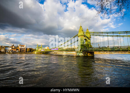 Hammersmith Bridge à Londres sur la Tamise à marée haute avec la circulation et les gens sur le pont. En fin d'après-midi, faible lumière du soleil Banque D'Images
