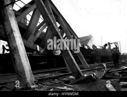 Juin 06, 1957 - 6-12-57 le sauvetage se passe dans la catastrophe ferroviaire de Lewisham. Les ingénieurs s'efforcer d'élever plus de fly-bridge Ã¢â€" La peine de rouleau a maintenant atteint 92 dans nightÃ mercredi¢â€ rail Lewisham catastrophe. Les sauveteurs ont travaillé toute la nuit sous les lumières de l'arc, et tôt ce matin, les ingénieurs ont essayé de soulever le pont détruit pour effacer le coach sur lequel tout le poids de la mouche-plus est passée. Photo montre : avec de lourdes prend en charge renforcé contre le pont de survol pour l'empêcher de s'effondrer, nous voyons une image claire de l'entraîneur de la mort sur lequel il s'est effondré. (Crédit Image : © Agence Keystone Press Banque D'Images