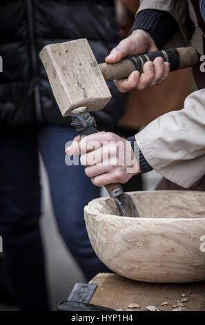 Man's hands du menuisier ne un bol, bat un marteau sur un burin Banque D'Images