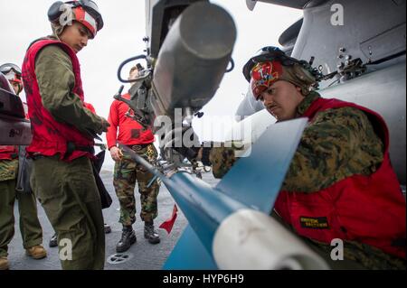 Les Marines américains charger un USMC AV-8B Harrier II Aéronefs d'attaque avec un cycle de formation à guidage laser à bord de la classe Wasp USN navire d'assaut amphibie USS Bonhomme Richard 13 mars 2017 dans la mer des Philippines. Banque D'Images