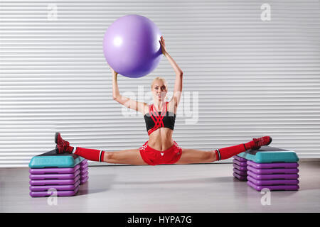 Belle jeune femme remise en forme souple faisant se divise au cours de sa w Banque D'Images